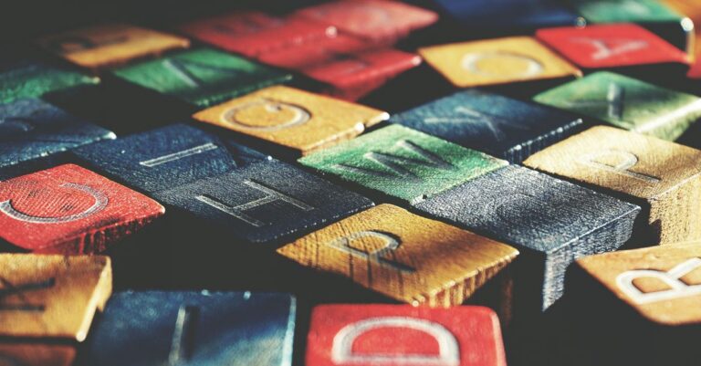 Vintage-style close-up of colorful wooden alphabet blocks creating an artistic pattern.