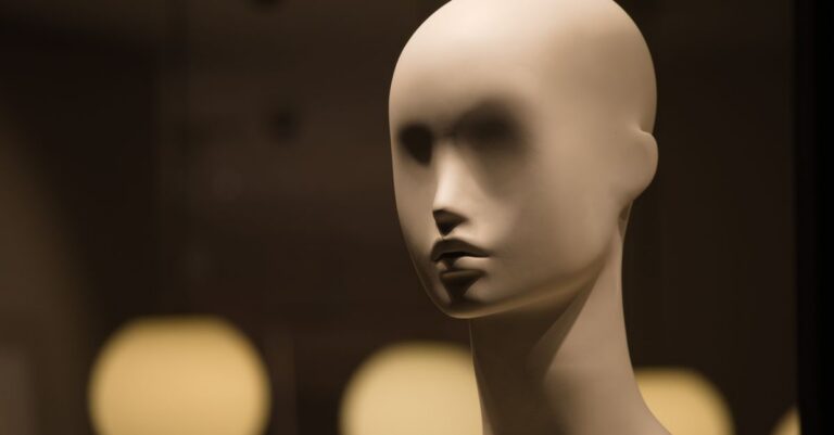 Close-up of an abstract mannequin in soft, moody lighting indoors.