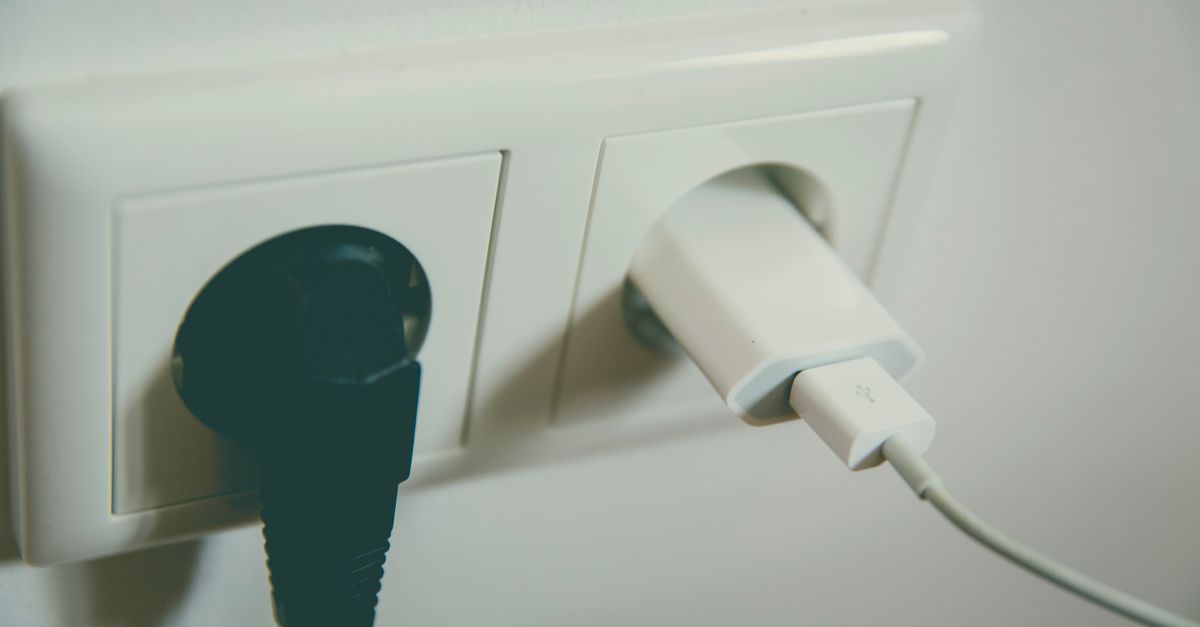 A close-up view of a wall outlet with two plugs inserted, capturing the simplicity of electrical connectivity.