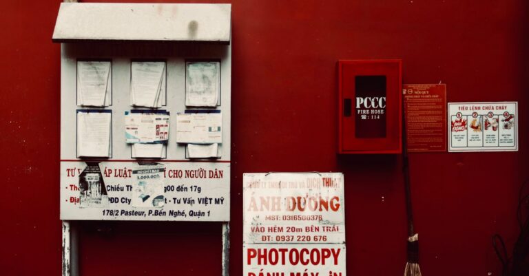 City environment with notices and fire hose on a vibrant red wall.