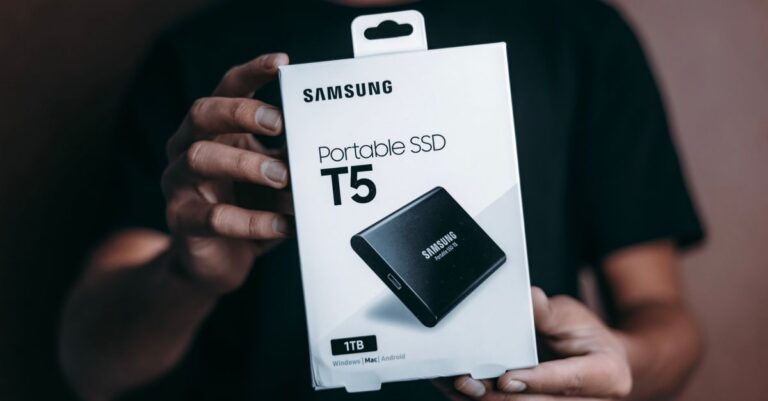 Close-up of a person holding a Samsung T5 Portable SSD box, emphasizing modern technology.