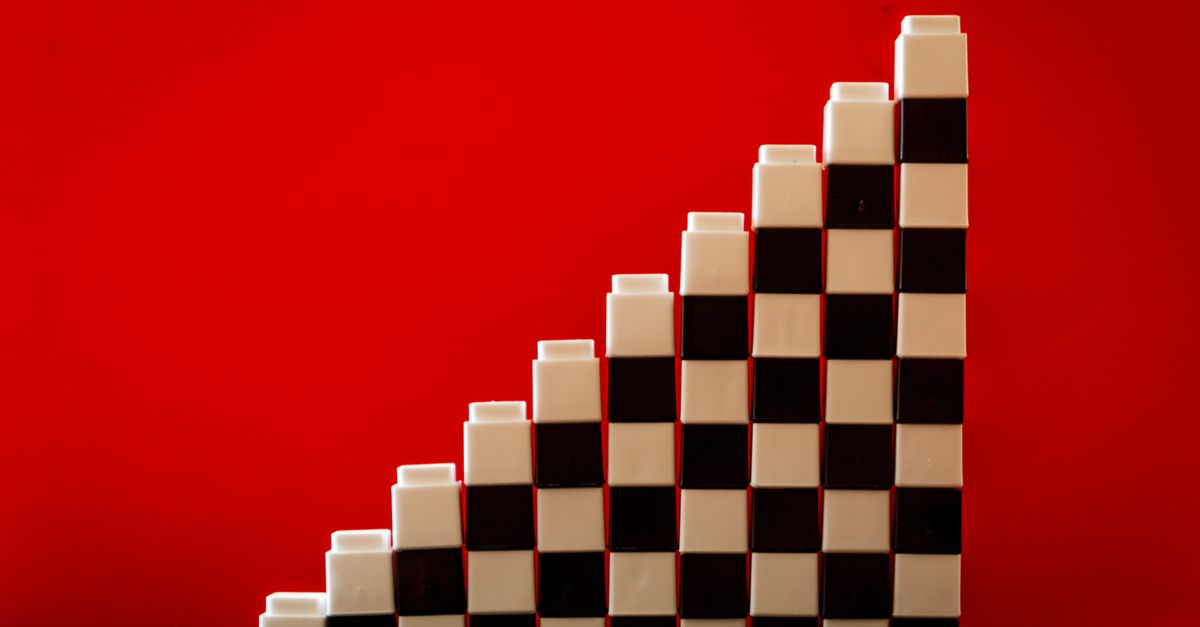 Checkered pattern blocks arranged in a stair formation against a vivid red backdrop.