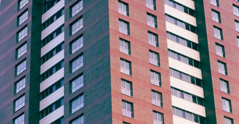 Close-up of a modern high-rise building with glass windows and geometric patterns.