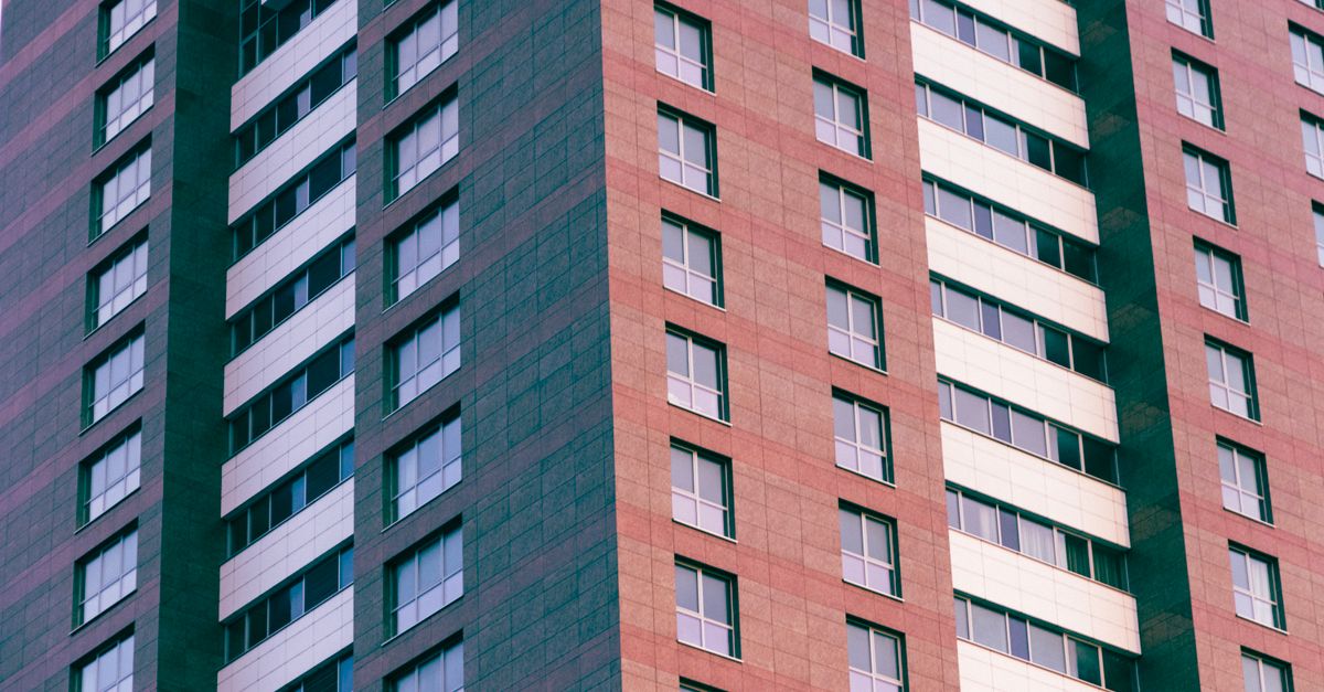 Close-up of a modern high-rise building with glass windows and geometric patterns.
