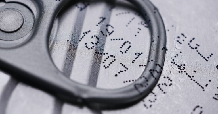 Detailed image of a drink can lid showing printed expiration date.