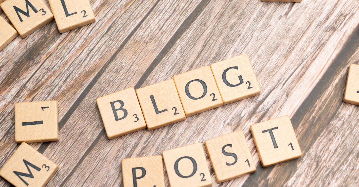 Wooden letter tiles spelling 'Blog Post' on a wooden background, ideal for online media concepts.