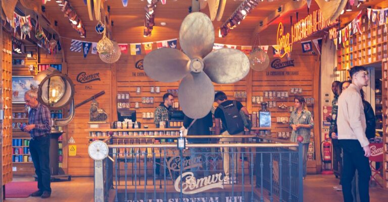 A vibrant nautical themed store interior with flags and a large propellor decoration.