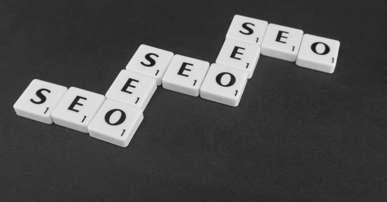 SEO spelled with Scrabble tiles on a black surface, representing search engine optimization concepts.