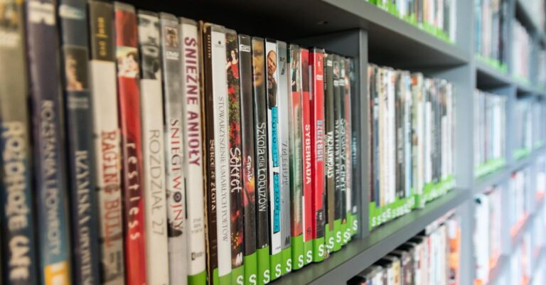 Close-up of a library shelf filled with DVDs showcasing various titles and colors.