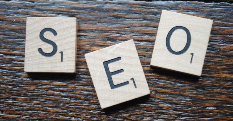 Close-up of Scrabble tiles spelling SEO on a wooden table for content strategy.